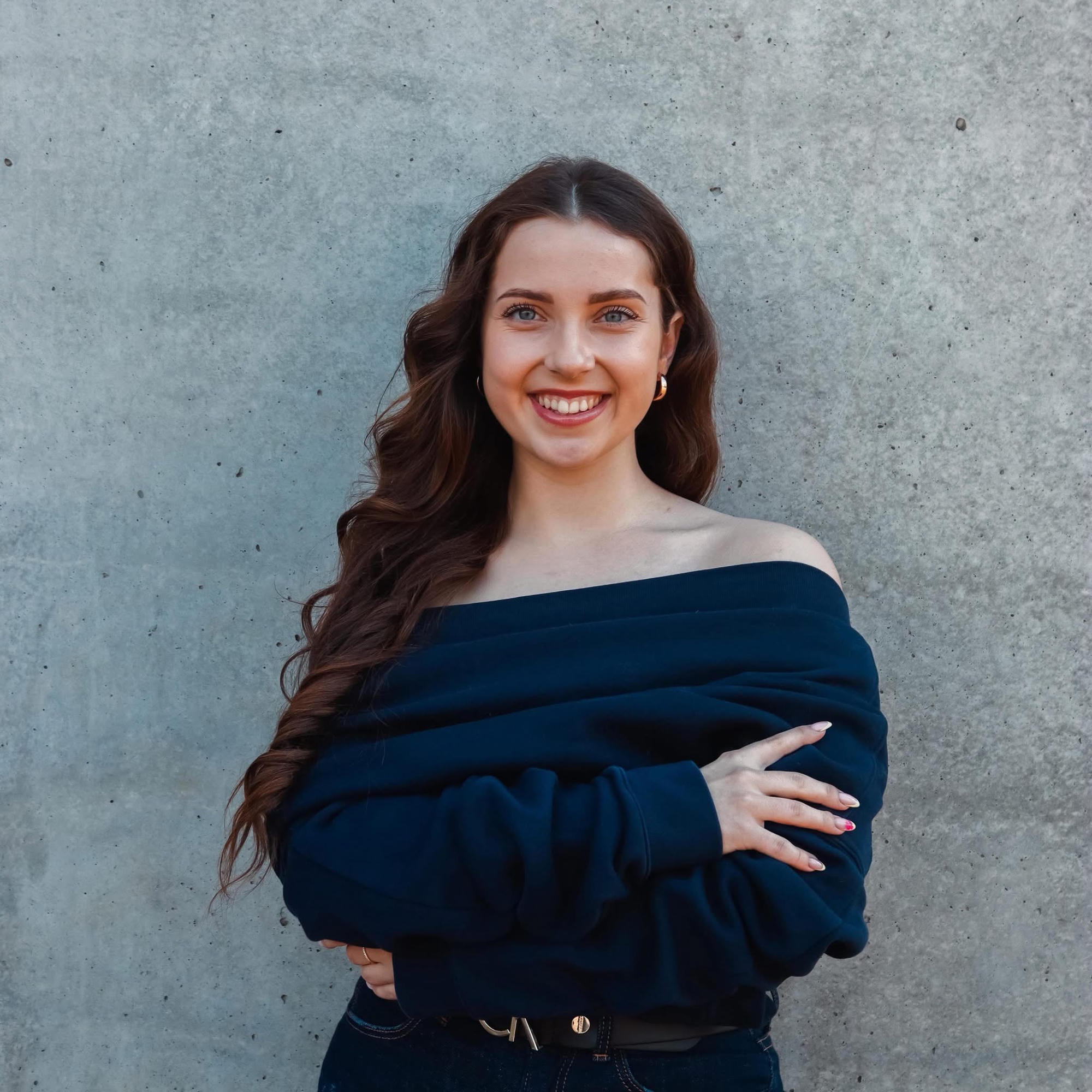 Karīna Martinova — confident professional portrait, smiling with arms crossed